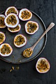 Halved passion fruits and a spoon of fruit flesh