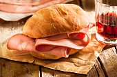 A mortadella roll on a piece of paper