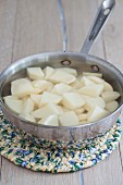 Peeled and diced potatoes in a saucepan of water