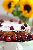 A summery cherry cake with sunflowers in the background