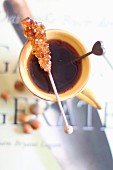 A rock candy stick on a cup of tea