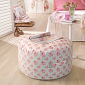 Pouffe with hand-sewn, floral cover in romantic, feminine bedroom
