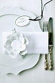 White place setting with china flower and tag labelled 'Bon appétit'