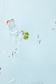 Bügelflasche & Glas mit Wasser auf weißem Untergrund