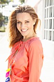 A young blonde woman wearing a salmon pink blouse