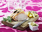 Crispy roast pork with rosemary potatoes on a wooden board