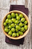 Fresh green olives in a wooden bowl