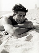 A young, sporty, topless man on a beach