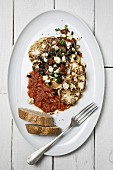 Cauliflower steaks with tomato sauce and feta cheese