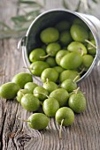 Green olives on a rustic wooden surface
