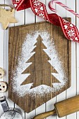 A Christmas tree print in icing sugar on a chopping board