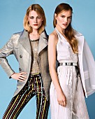 Zwei Frauen im Disco-Glam-Look vor hellblauem Hintergrund