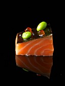 An amuse bouche with salmon on a black surface