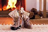 St. Nicholas gifts with name tags in laced boots in front of open fire