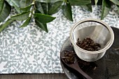 Used black tea leaves in a tea strainer