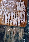 Puff pastry rolls with icing sugar on baking paper