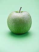A green apple on a green surface