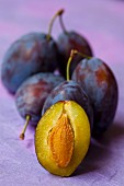 Fresh plums, whole and halved