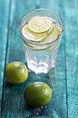 A glass of water with limes
