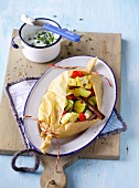 Colourful vegetables in parchment paper with herb quark