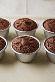 Warm fondants au chocolate in baking tins on a baking tray