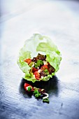 Tomato salad with feta cheese on a lettuce leaf