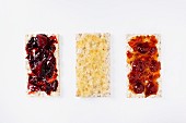 Three crispbreads with jam and honey (seen from above)