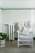 White wicker chair with pale, striped cushions against tiled dado in conservatory