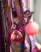 Silver bird, pink baubles and ribbons used as Christmas decorations