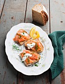 Slices of bread topped with salmon, dill and horseradish cream