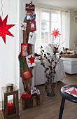 Weihnachtlich geschmücktes Wohnzimmer - Postkarten auf Fundholz an Wand befestigt, Weihnachtsdeko und Geschenke