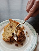 A slice of cake being cut with a fork