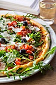 Pizza bruschetta with olives, cheese, rocket and tomato