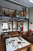 Coffee table with picture engraved on stone top and brown, velvet sofa set in open-plan interior with mezzanine