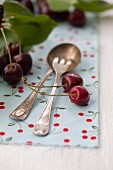 Silver cutlery with cherries and cherry leaves