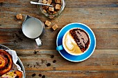Kaffee mit Milchschaum, Zuckerwürfel und Blätterteigschnecke