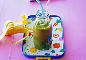 A banana and pear smoothie with dates, lettuce and carrots leaves