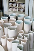 White, hand-crafted ceramic vases of various sizes in workshop
