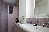 Mauvefarbenes Bad mit Wandarmaturen, Waschbecken und Duschbereich, Vintage Wandspiegel