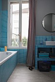 Pale blue bathroom with mosaic tiles, grey-painted walls and vintage ambiance