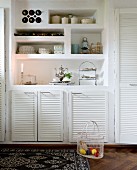 Masonry dresser in wall with open-fronted niches and white-painted louvre doors