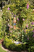 Rosa Fingerhut in idyllischem Garten mit Gartendeko