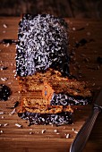 A loaf cake with chocolate glaze and grated coconut