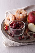 Apple doughnuts with sugar, candied fruit and fresh apples