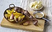 Roast beef skewers with roast potato wedges and shallots
