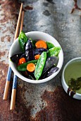 Fried purple and green mange tout with carrots