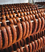 Lots of sausages hanging on a metal rack