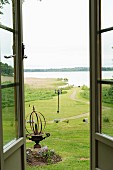 View of lawn leading down to lake through open terrace doors