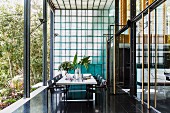 Modern white dining table and black chairs on black-tiled terrace