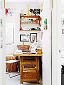 Laptop and family photos on rustic desk below trophies and various items on wooden wall-mounted shelves